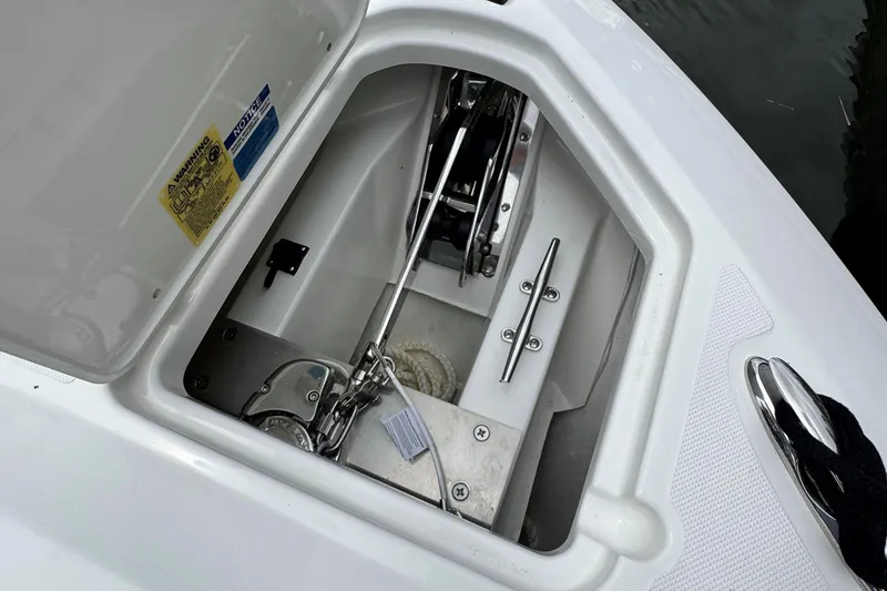 Slide: The Image of Anchor compartment of 2026 Pursuit DC 266 Dual Console boat, featuring chain and rope storage. - 21
