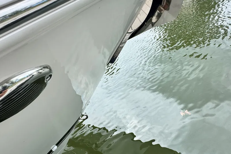 Slide: The Image of 2026 Pursuit DC 266 Dual Console boat hull reflecting on water surface. - 22