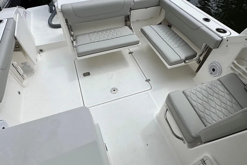 Slide: The Image of 2026 Pursuit DC 266 Dual Console boat interior with gray seating and white deck. - 7