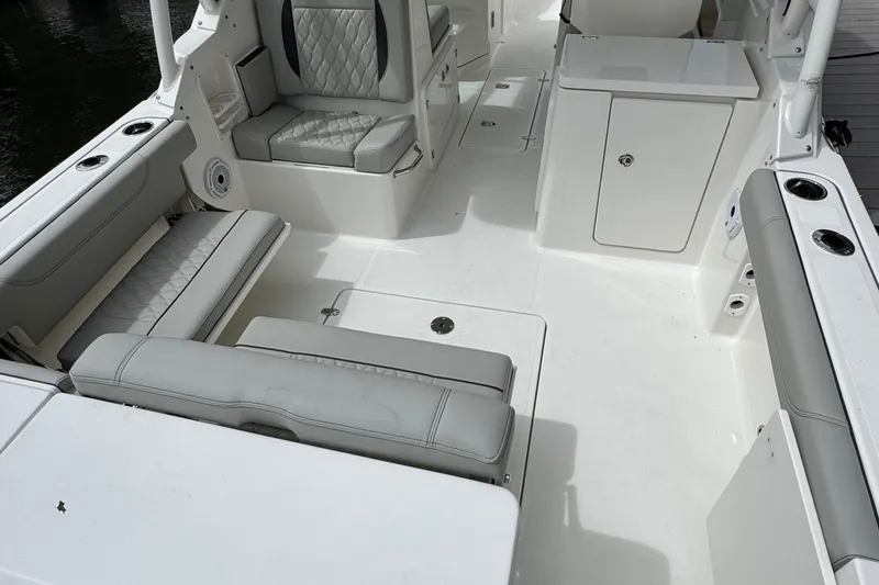 Slide: The Image of 2026 Pursuit DC 266 Dual Console boat interior with cushioned seating and storage compartments. - 8