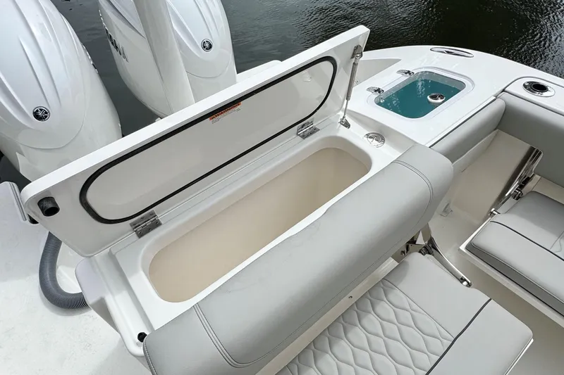 Slide: The Image of 2026 Pursuit DC 266 Dual Console boat interior with open storage compartment and seating. - 9