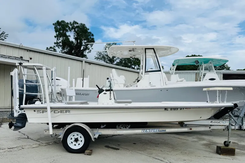 Slide: The Image of 2014 Spyder FX17 boat on trailer, parked outdoors near other boats. - 3