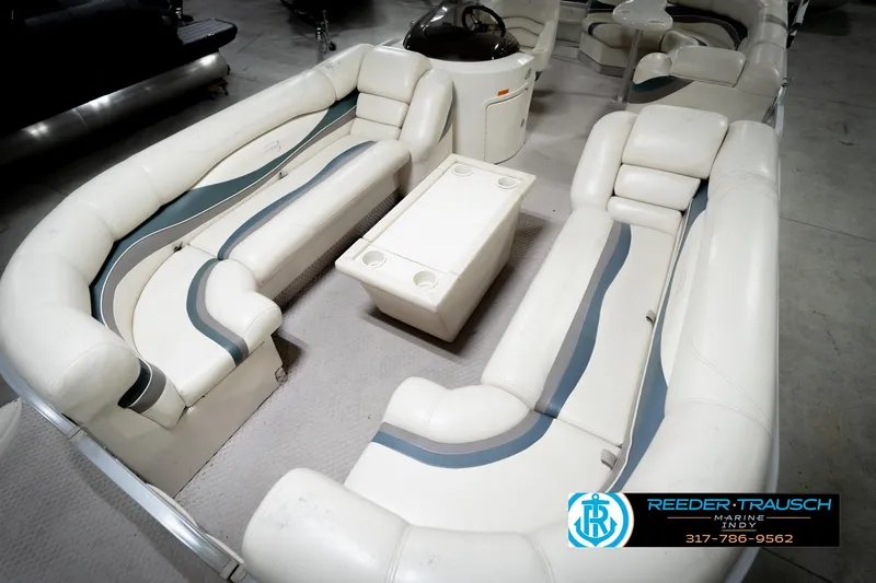 Slide: The Image of 2006 Bennington 2250RL boat interior with white seating and central table. - 11