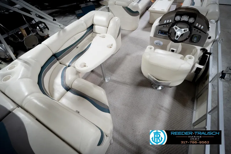 Slide: The Image of Interior of a 2006 Bennington 2250RL pontoon boat with plush seating and steering console. - 13