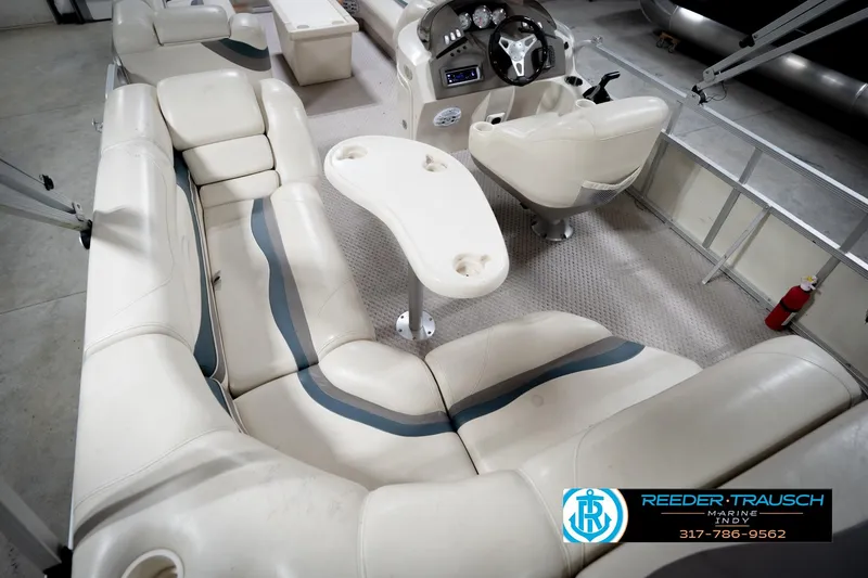 Slide: The Image of 2006 Bennington 2250RL boat interior with beige seating and steering console. - 14