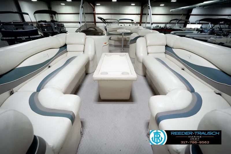 Slide: The Image of 2006 Bennington 2250RL pontoon boat interior with plush seating and table in showroom. - 15