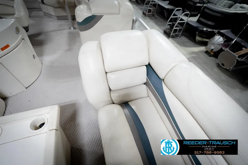 Slide: The Image of 2006 Bennington 2250RL boat interior with white and blue seating, showcased at Reeder-Trausch Marine. - 23