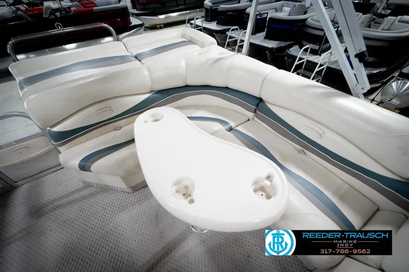 Slide: The Image of 2006 Bennington 2250RL boat interior with white seating and table, Reeder Trausch Marine logo. - 25