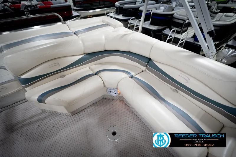Slide: The Image of 2006 Bennington 2250RL boat interior with white and gray seating, showroom display. - 26