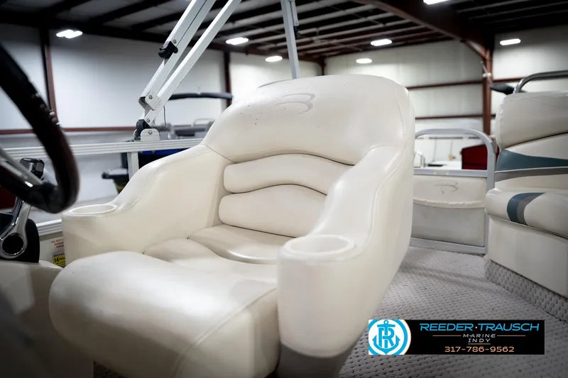 Slide: The Image of 2006 Bennington 2250RL boat interior with plush white seating in a showroom. - 38
