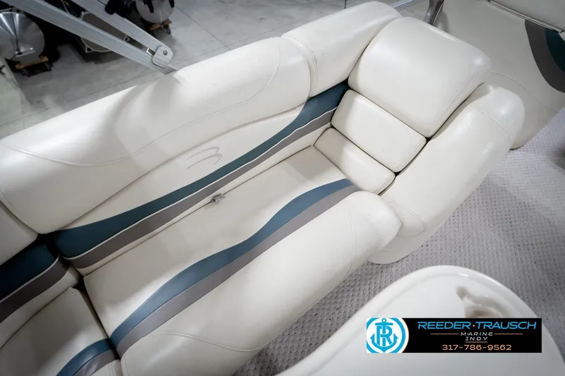 Slide: The Image of 2006 Bennington 2250RL boat interior with white and blue seating, Reeder-Trausch Marine logo. - 40