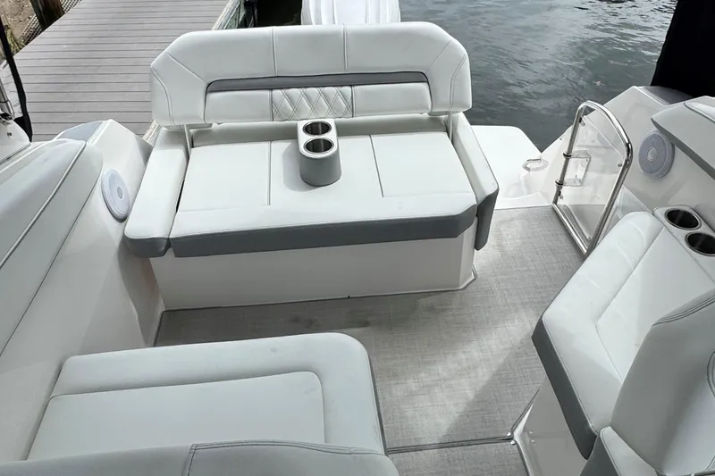 Slide: The Image of 2026 Regal 26 XO boat interior with white seating and cup holders by the water. - 11