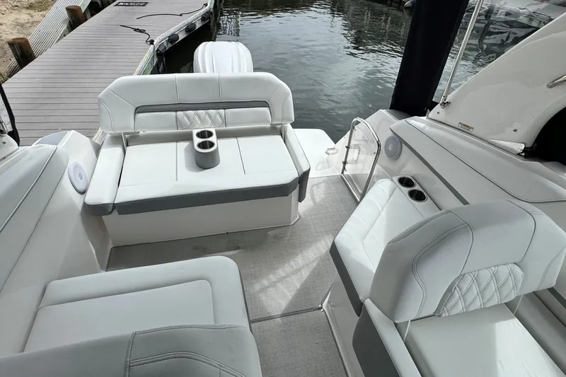 Slide: The Image of 2026 Regal 26 XO boat interior with white seating and cup holders by the dock. - 12