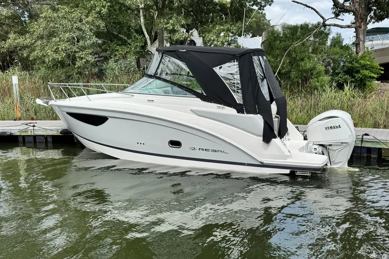 Slide: The Image of 2026 Regal 26 XO boat docked with Yamaha outboard, featuring sleek design and black canopy. - 2
