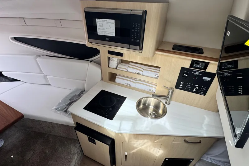 Slide: The Image of Compact kitchen area in 2026 Regal 26 XO boat with microwave, sink, and stove. - 22