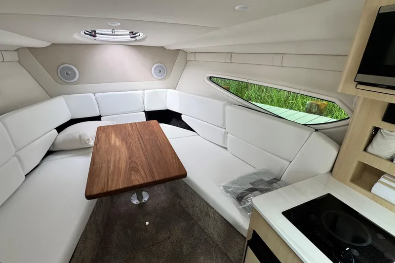 Slide: The Image of Luxurious interior of 2026 Regal 26 XO boat with white seating and wooden table. - 26