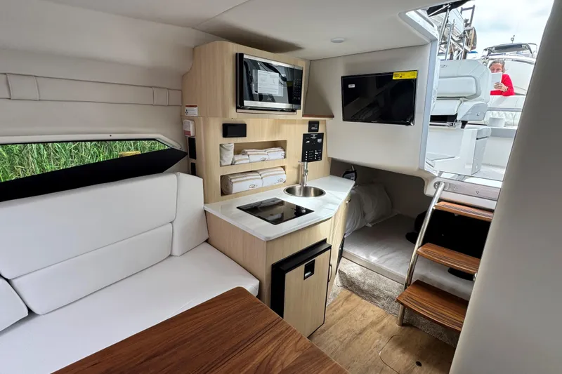 Slide: The Image of Interior of 2026 Regal 26 XO boat featuring kitchenette, seating, and modern amenities. - 27
