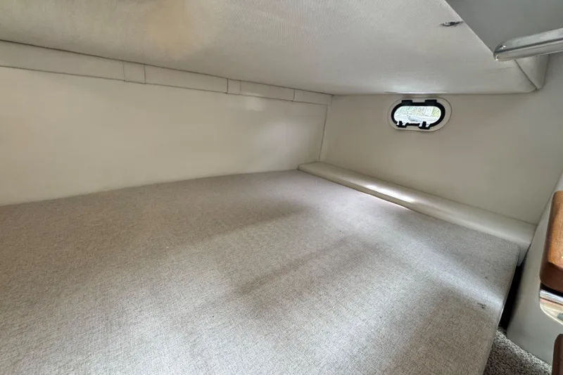 Slide: The Image of 2026 Regal 26 XO cabin interior with small window and cushioned sleeping area. - 30