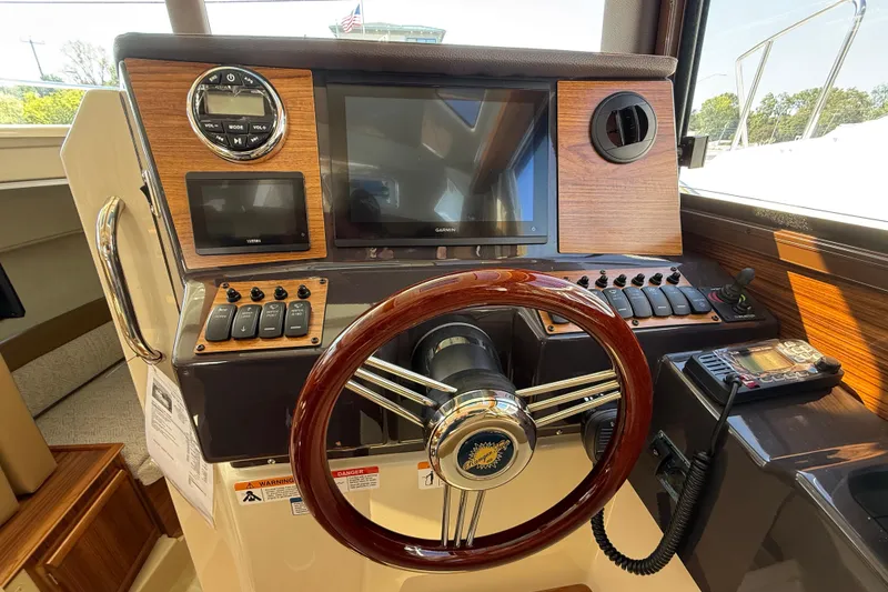 Slide: The Image of Helm of 2026 Ranger Tugs R-25 with wooden accents and modern navigation controls. - 10