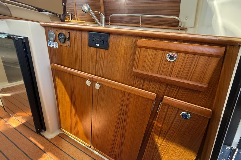 Slide: The Image of 2026 Ranger Tugs R-25 interior with wood cabinetry and modern fixtures. - 12
