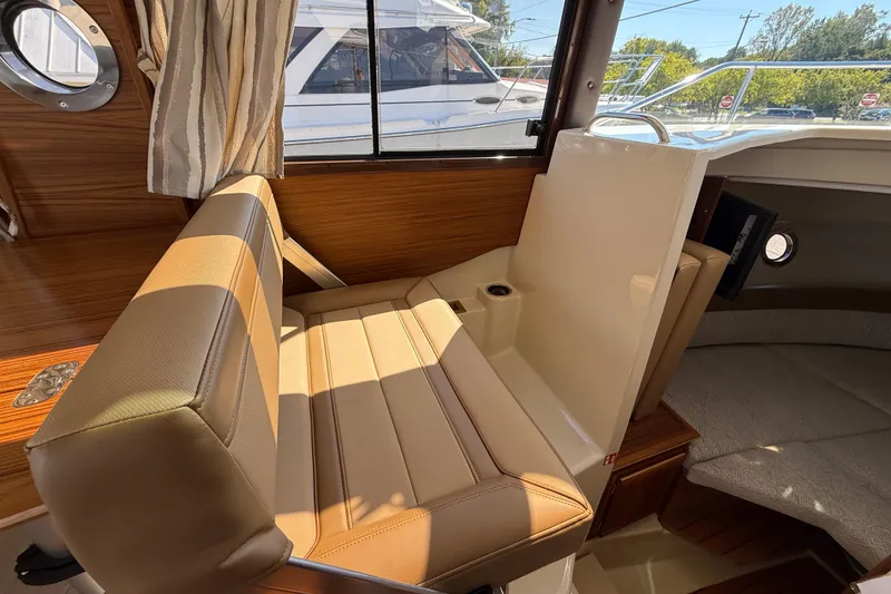 Slide: The Image of Interior of 2026 Ranger Tugs R-25 boat with beige seating and wood accents. - 16