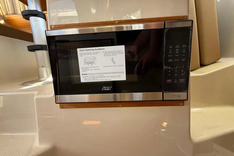 Slide: The Image of Microwave in 2026 Ranger Tugs R-25 boat interior, featuring Zest brand and control panel. - 23