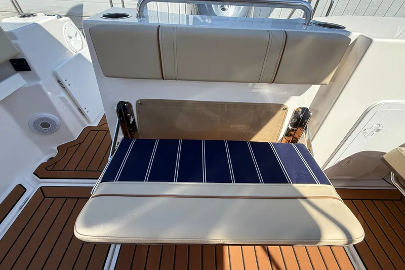 Slide: The Image of 2026 Ranger Tugs R-25 boat seat with striped cushion and teak flooring. - 26