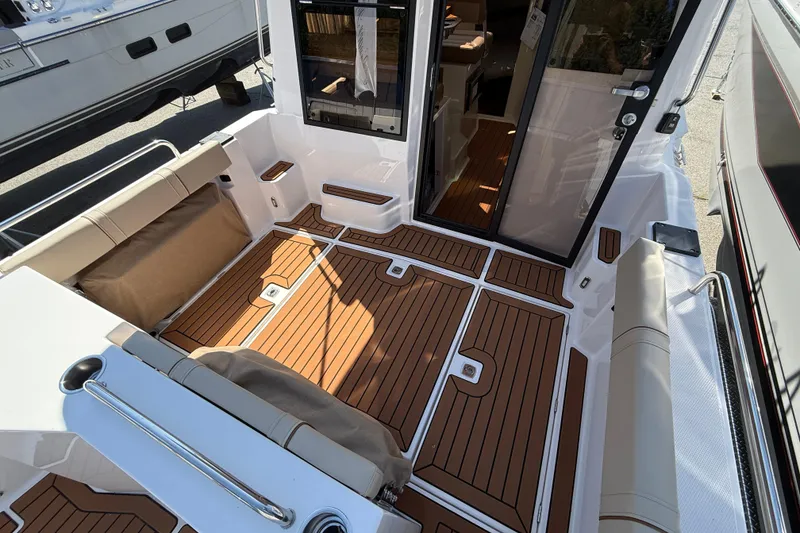 Slide: The Image of 2026 Ranger Tugs R-25 boat interior with teak flooring and cushioned seating. - 4