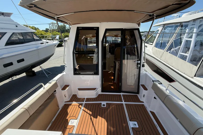 Slide: The Image of 2026 Ranger Tugs R-25 boat interior with teak flooring and seating area. - 5