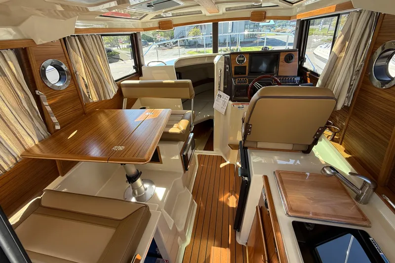 Slide: The Image of Interior of 2026 Ranger Tugs R-25 boat, featuring wood accents and modern amenities. - 6
