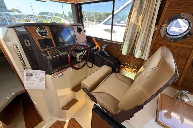 Slide: The Image of 2026 Ranger Tugs R-25 helm with leather seat, modern controls, and wood accents. - 8