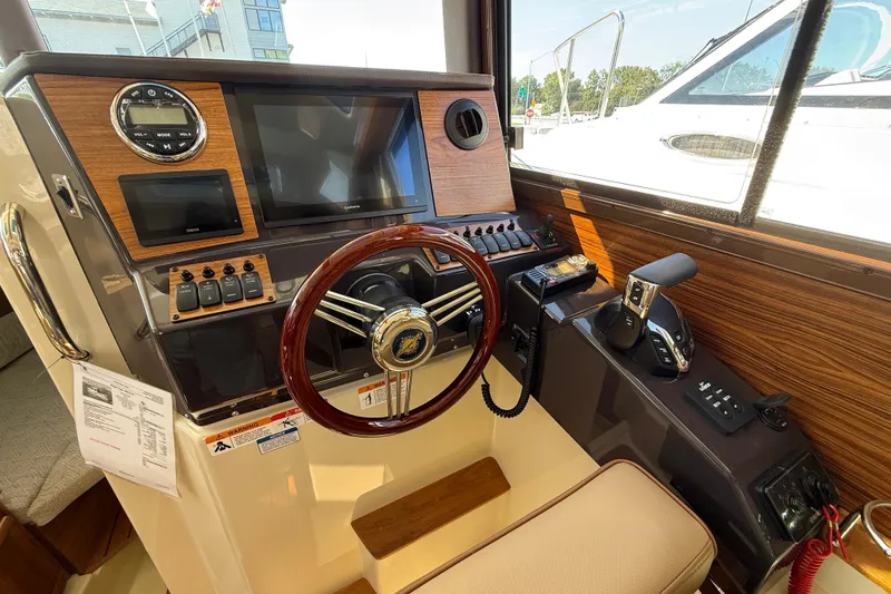 Slide: The Image of 2026 Ranger Tugs R-25 helm with modern controls and wood accents. - 9