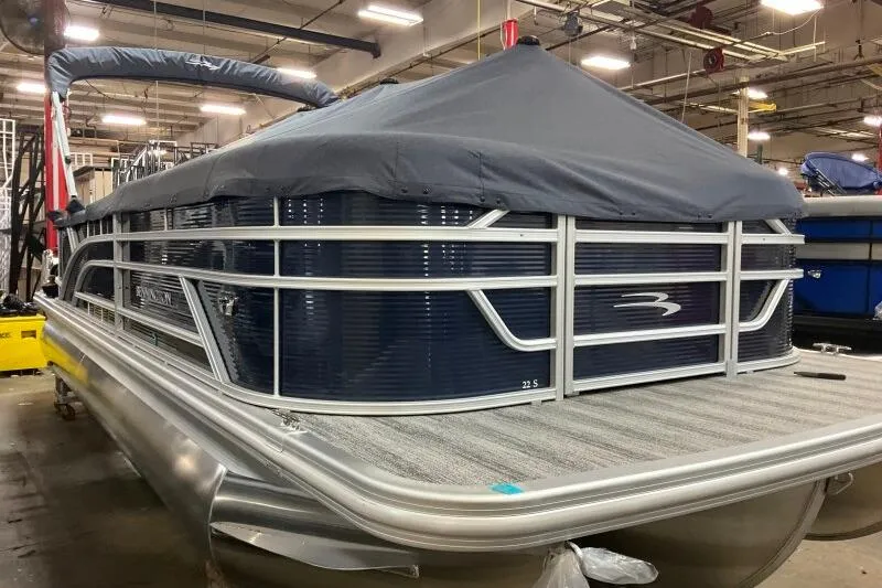 Slide: The Image of 2026 Bennington 23SL pontoon boat with cover in a warehouse setting. - 4