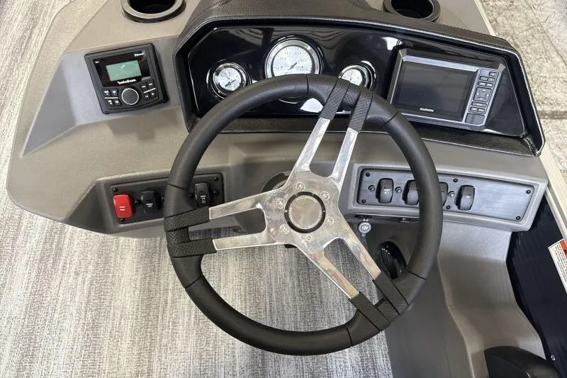 Slide: The Image of 2026 Bennington 23SL boat dashboard with steering wheel, gauges, and Garmin display. - 9