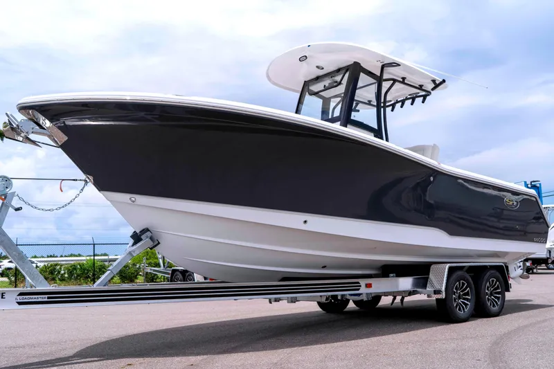 The Image of 2026 Sea Hunt Gamefish 25 boat on trailer, displayed outdoors under cloudy sky. - 0