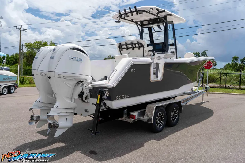 Slide: The Image of 2026 Sea Hunt Gamefish 25 boat with dual Yamaha engines on a trailer. - 10
