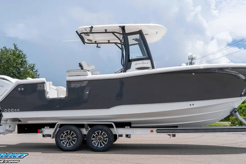 Slide: The Image of 2026 Sea Hunt Gamefish 25 boat on trailer, side view, under cloudy sky. - 11