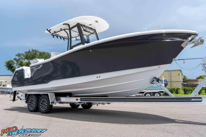 Slide: The Image of 2026 Sea Hunt Gamefish 25 boat on trailer, sleek design, outdoor setting. - 12