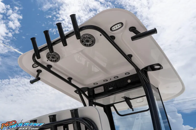 Slide: The Image of 2026 Sea Hunt Gamefish 25 T-top with rod holders and speakers against a cloudy sky. - 13