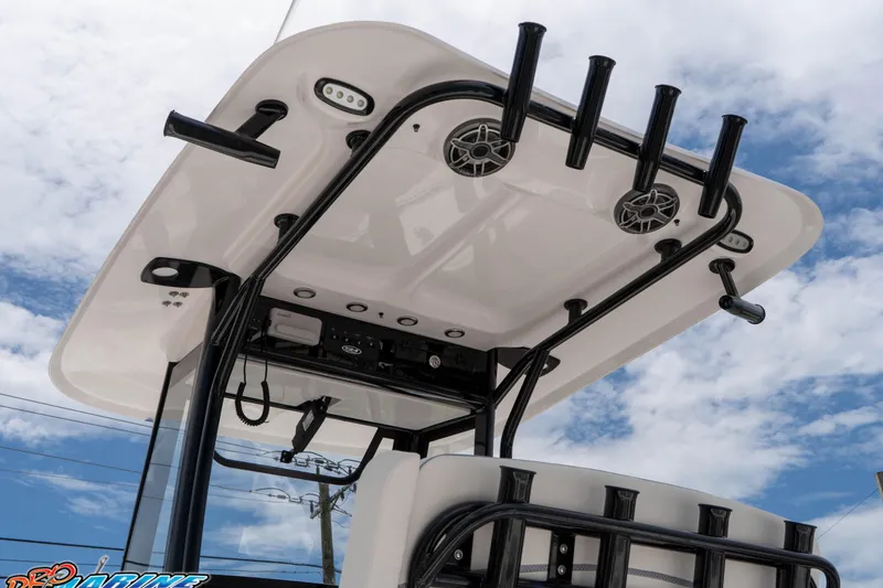Slide: The Image of 2026 Sea Hunt Gamefish 25 boat with rod holders and speakers under a clear sky. - 14