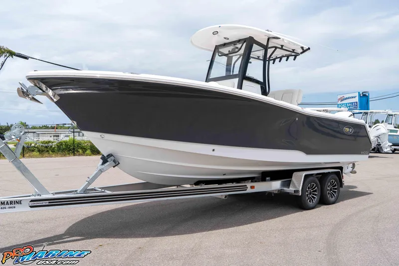 Slide: The Image of 2026 Sea Hunt Gamefish 25 boat on trailer, displayed outdoors at a dealership. - 3