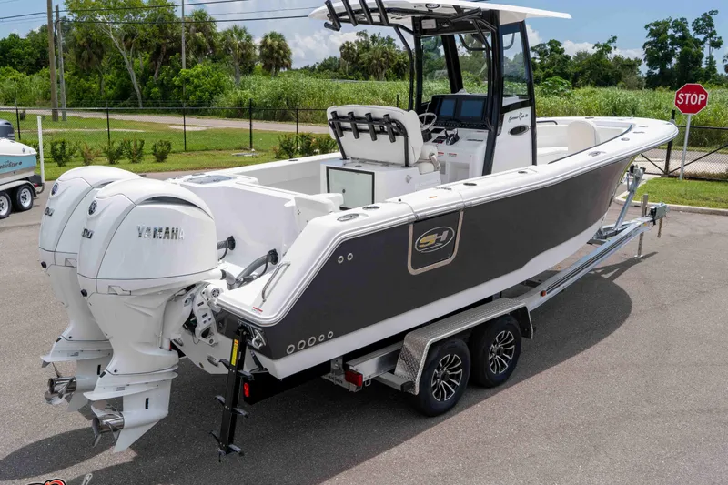 Slide: The Image of 2026 Sea Hunt Gamefish 25 boat with dual Yamaha engines on a trailer. - 39