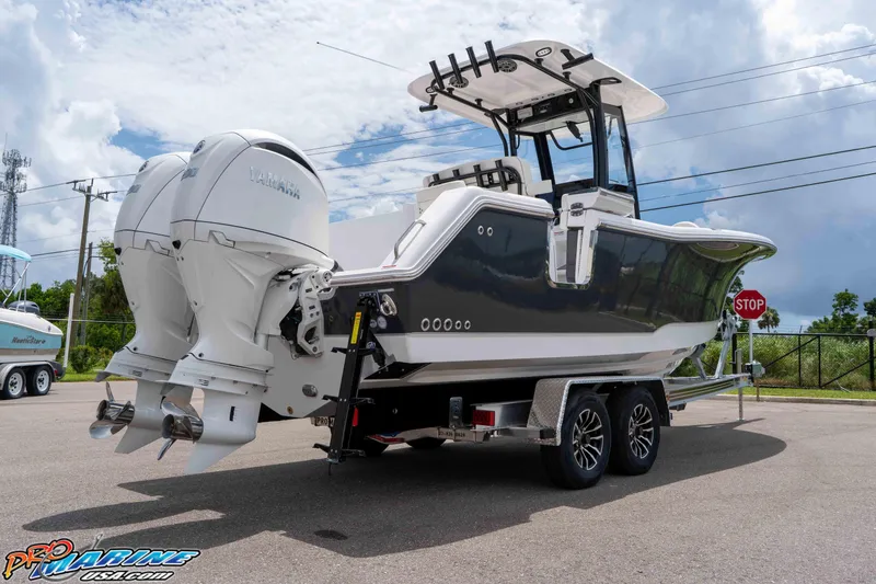 Slide: The Image of 2026 Sea Hunt Gamefish 25 boat on trailer with dual Yamaha engines, parked outdoors. - 9