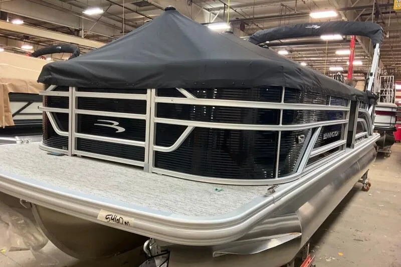 Slide: The Image of 2026 Bennington 23SL pontoon boat with black cover in a showroom. - 3