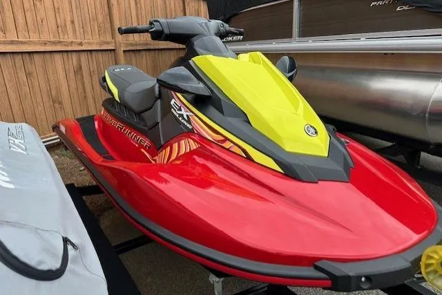 Slide: The Image of 2024 Yamaha WaveRunner EX Limited in vibrant red and yellow, parked on a trailer. - 11