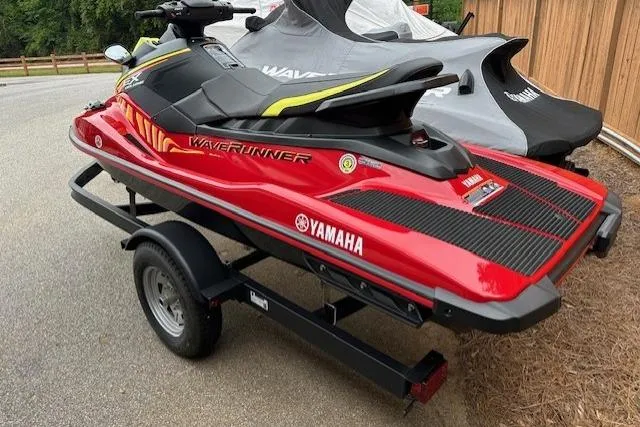 Slide: The Image of 2024 Yamaha WaveRunner EX Limited in red on a trailer, parked outdoors. - 12