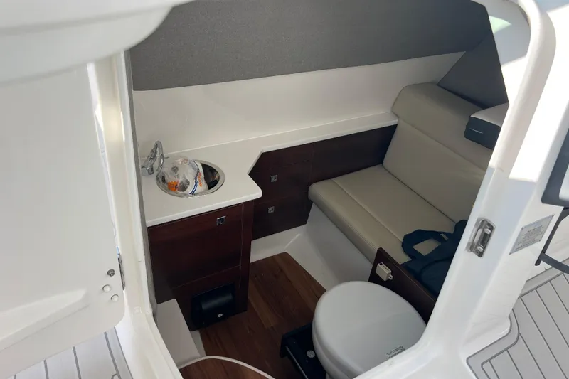 Slide: The Image of 2020 Chaparral 280 OSX boat interior with seating, sink, and toilet. - 18