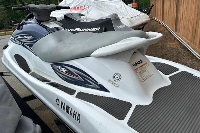 Slide: The Image of 2011 Yamaha WaveRunner VX Deluxe jet ski, white and blue, parked outdoors. - 11