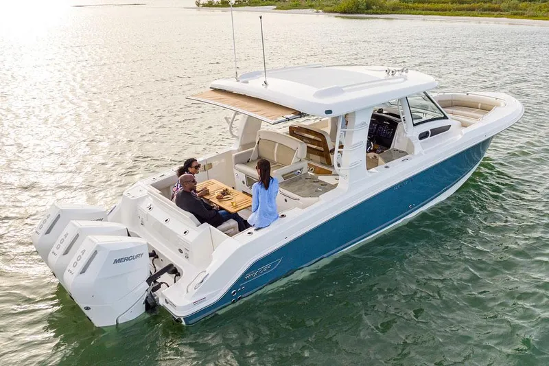 Slide: The Image of Manufacturer Provided Image: 2025 Boston Whaler 350 Realm boat on water, featuring spacious deck and dual Mercury engines. - 2