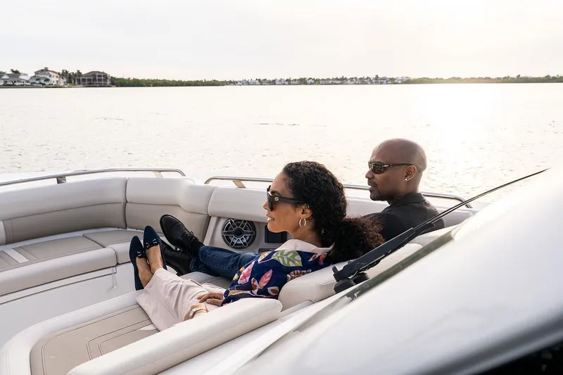 Slide: The Image of Manufacturer Provided Image: Couple relaxing on a 2025 Boston Whaler 350 Realm boat, enjoying a serene water view. - 4